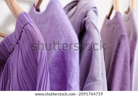 Closeup of fashionable tops in trendy purple, very peri, lavender colors on a shopping rail. 