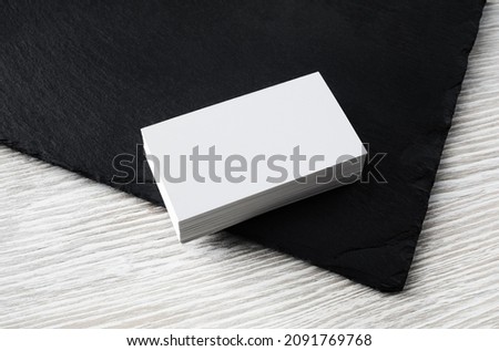 Blank white business cards on stone board background. Mockup for branding identity. Template for graphic designers portfolios.