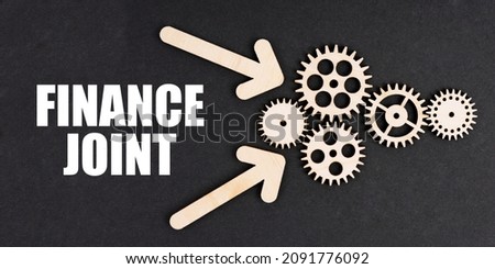 Business and finance concept. On the black surface, arrows, gears and an inscription - FINANCE JOINT