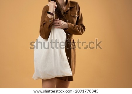 Young woman holding white cotton bag in her hands. Zero waste concept. Mockup. Eco friendly lifestyle.