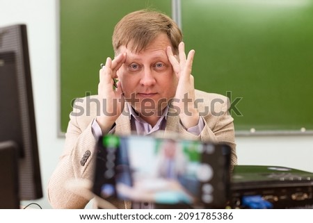 A tired math teacher clutched his head during an online lesson.