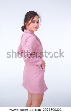 Young business charming confident woman in pink suit at the studio white background.