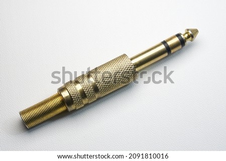 6.35mm male TRS jack or stereo jack for musical instruments or audio devices. Gold plated jack connector on white background isolated. Royalty-Free Stock Photo #2091810016