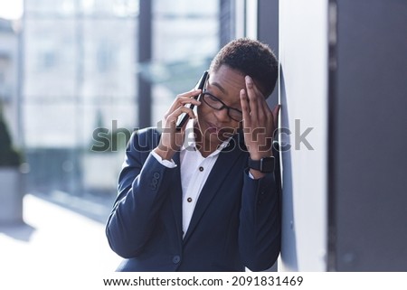 Woman businessman sad complains on the phone, reports bad news, African American woman in despair near the office, holding hands behind his head Royalty-Free Stock Photo #2091831469