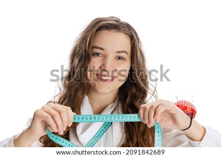 Measurement. Close-up portrait of smiling young girl, dressmaker posing isolated on white background. Concept of job, hobby, fashion, style and studying. Copy space for ad