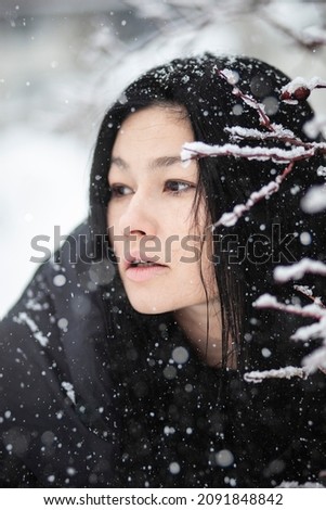 Portrait of a woman near a branch. Winter photo session