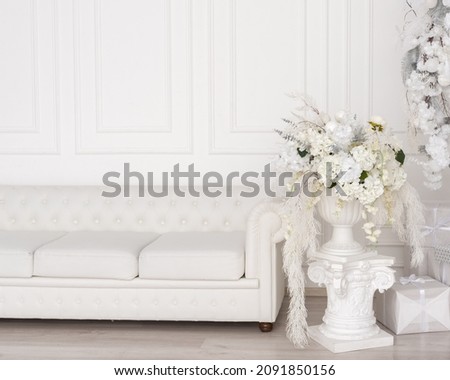 white sofa and white vase with flowers