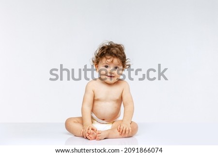 Healthcare, infant. New generation. Portrait of little cute toddler boy, baby in diaper sitting isolated over white studio background. Concept of childhood, motherhood, life, birth. Copy space for ad Royalty-Free Stock Photo #2091866074