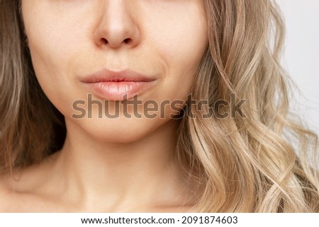 Cropped shot of a young caucasian blonde woman with wavy hair. Close up of a lower part of the face with clear highlighted cheekbones. Plastic surgery buccal fat removal. Result of cosmetic surgery Royalty-Free Stock Photo #2091874603
