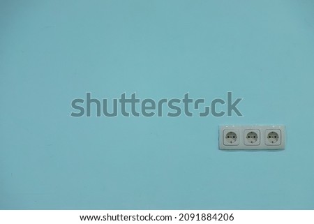 white electrical outlet on a blue wall, background.