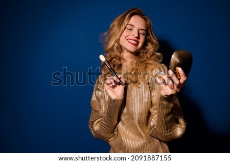 Beautiful girl with brush looking approvingly in mirror