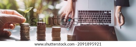 Saving money concept. Hand putting money coin stack with growing business graph. Panoramic business banner with copy space.