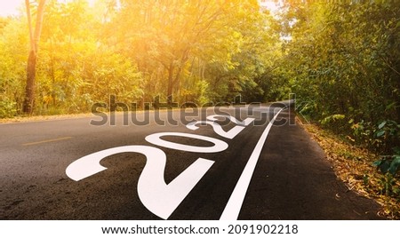 The new year 2022 or straightforward concept. Text 2022 written on the road in forest. planning and challenge, business strategy, opportunity, hope, exit, and new life. Royalty-Free Stock Photo #2091902218
