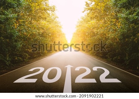 The new year 2022 or straightforward concept. Text 2022 written on the road in the middle of asphalt road at sunset. planning and challenge, business strategy, opportunity, hope, and new life. Royalty-Free Stock Photo #2091902221