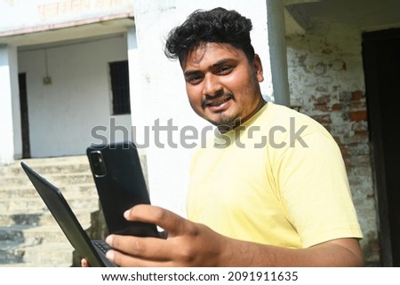 An Indian businessman using phone and laptop