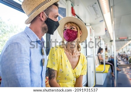 Image of a happy couple sitting in the metro commuter during 2020 pandemic events