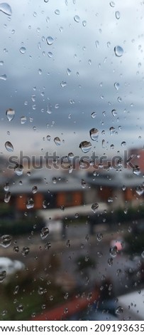 Close-up of raindrops hitting the window glass