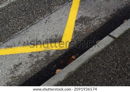 Yellow line of no parking area on grey asphalt road top view