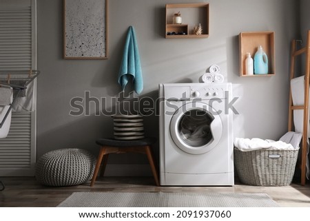 Laundry room interior with modern washing machine near light wall Royalty-Free Stock Photo #2091937060