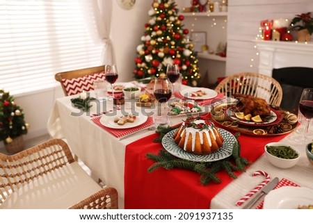 Festive dinner with delicious food and wine on table indoors. Christmas Eve celebration