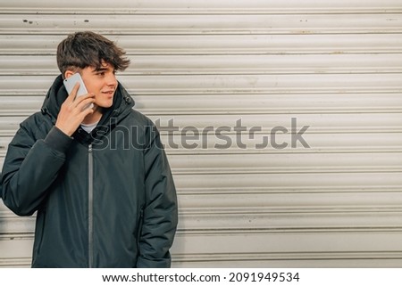 teenage boy talking on the mobile phone in the street