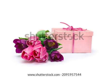 Bouquet of violet and pink tulips with pink gift box on a white background with space for text. Holiday spring composition