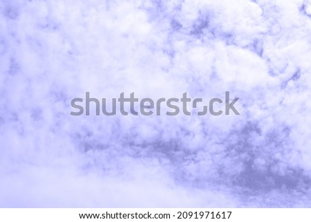 White fluffy cumulus clouds against a purple-red sky in pantone trending color 2022 very peri