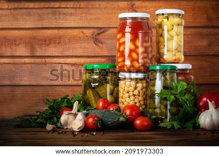 canned and fresh vegetables on wooden background