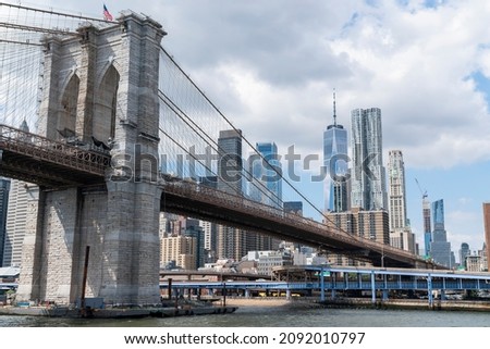 Brooklyn bridge with New York City Manhattan financial downtown skyline panorama at day time over East River with blue cloudy sky.