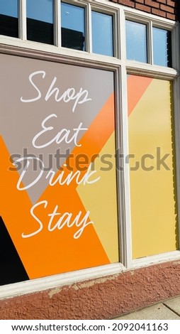 Shop Eat Drink Stay Sign on Retail and Restaurant Hotel Building Storefront in City