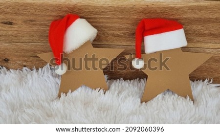 Two stars in Santa's hat on a wooden background - handmade idea for a Christmas greeting card.