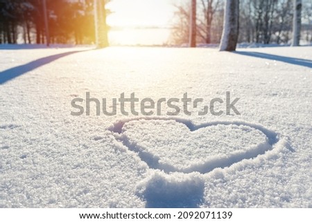 Nice heart shape on the fresh snow winter sunset lanscape,park or forest. Royalty-Free Stock Photo #2092071139