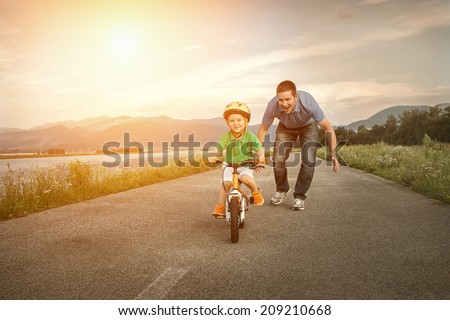 Happiness Father and son on the bicycle outdoor Royalty-Free Stock Photo #209210668