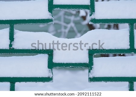 Winter background picture: fragment of snow covered fence. Winter time. Heavy snow.