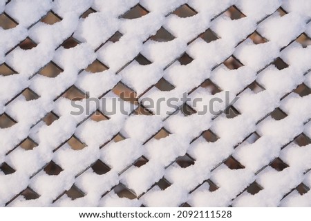 Winter background picture: fragment of snow covered fence. Winter time. Heavy snow.