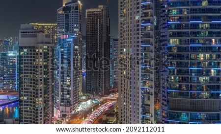 Dubai Marina Skyline with JBR district skyscrapers on a background aerial night timelapse. Illuminated towers with glass surface view from above