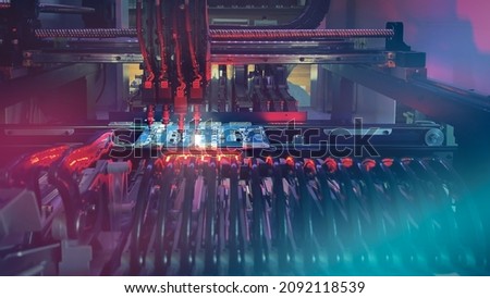 Production of modern productive electronic chips and boards on automatic SMT machine - Digital technologies for automation of industry. Red neon lights illuminate Chip Components for automation test. Royalty-Free Stock Photo #2092118539