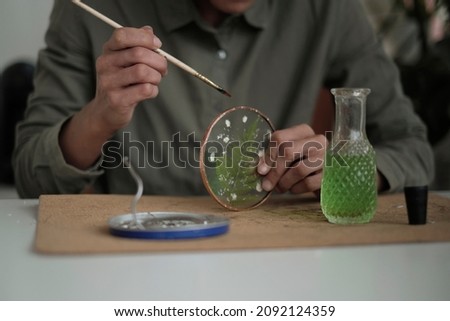 woman fixes glass plates. A picture of dried flowers. Master class on creating frame. be more creatively engaged. A Life of Happiness and Fulfillment