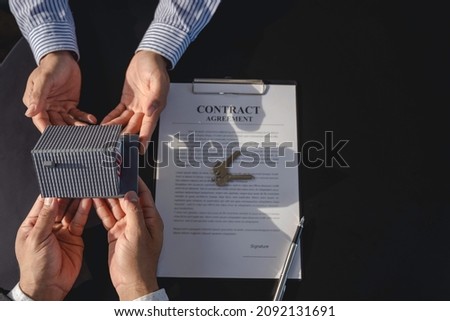 Real estate agents handing over Example of a house and a house price contract agreement Before handing over the house and keys to the customer, the concept of mortgage, purchase and home insurance