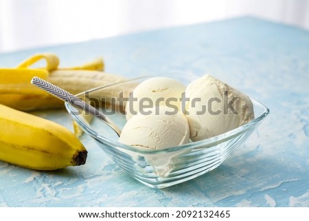Bowl with tasty banana ice-cream on color background, closeup