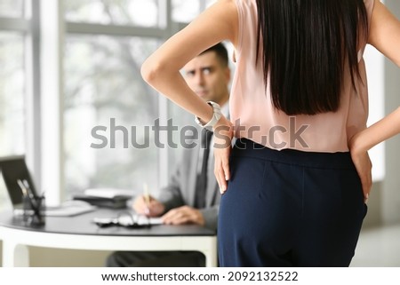 Beautiful young secretary seducing her boss in office. Concept of harassment Royalty-Free Stock Photo #2092132522