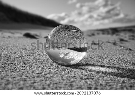glass globe on the beach of the baltic sea. Black and white photograph