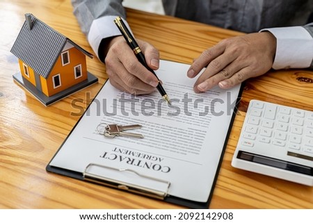 Man checking documents on table, housing salesman checking for correctness of contract documents before bringing customers to sign the deal. Real estate trading concept.