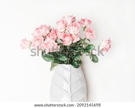 Bouquet of pink roses in ceramic vase. Floral still life with roses on white background. Front view