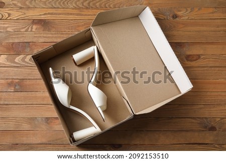 Wardrobe box with shoes on wooden background