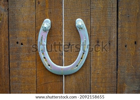 macro closeup of an old rusty aged weathered horseshoe horse shoe on wooden door symbol lucky charm of luck fortune and success 