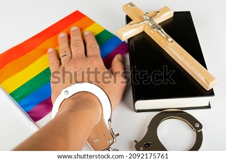 Picture of a bible, cross and a rainbow flag