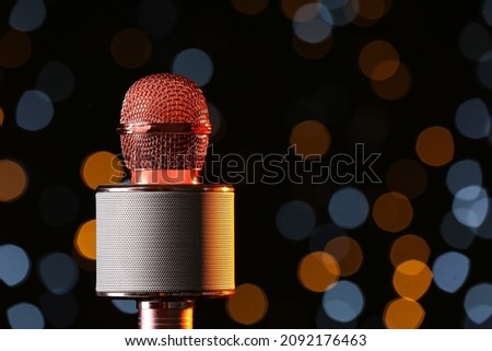 Modern microphone against defocused lights, closeup