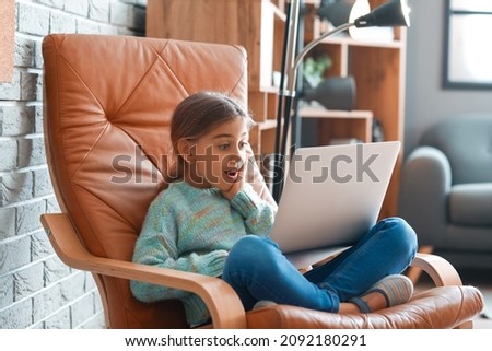 Surprised girl watching cartoons at home