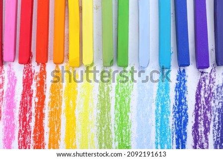 Colorful pastel chalks on white background, flat lay. Drawing materials